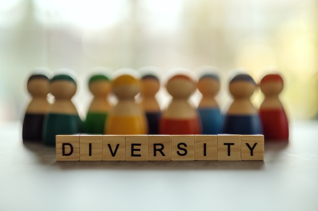 Palabra de diversidad en bloques de madera con un grupo de diferentes personas en el fondo