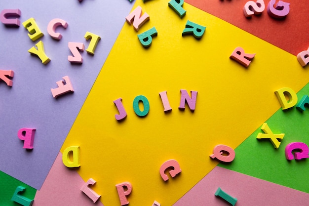 La palabra formada por letras multicolores de madera Letras dispersas sobre un fondo de color