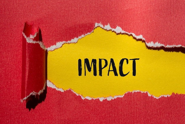 Palabra de impacto escrita en papel rojo rasgado con fondo amarillo Símbolo de palabra de impacto conceptual Copiar espacio