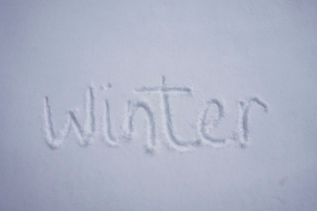 Palabra de invierno escrita en un fondo de nieve fría