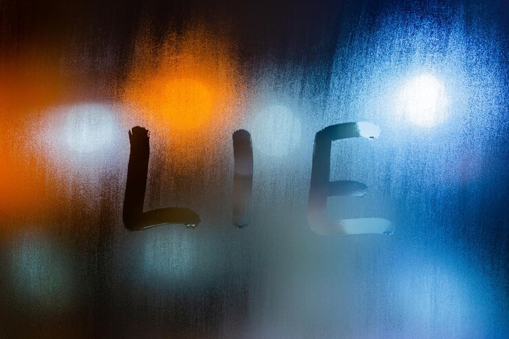 Foto la palabra mentira escrita en el primer plano de cristal de la ventana húmeda nocturna con fondo bokeh