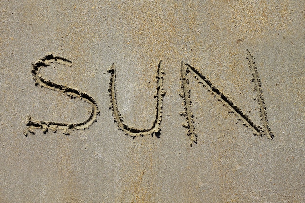 Palabra sol hechizo en la playa arena de verano