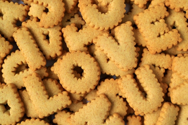 La palabra TE AMO, deletreada con galletas en forma de alfabeto en la pila de las mismas galletas.
