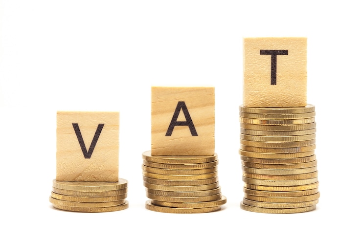 Foto palabra vat concept en bloque de madera sobre monedas apiladas.