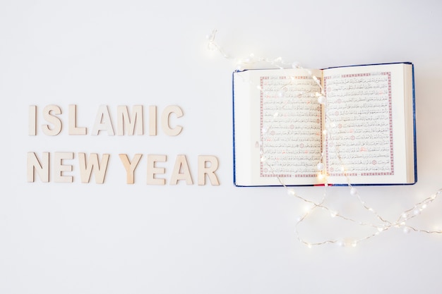 Foto palabras del año nuevo islámico y corán con guirnalda