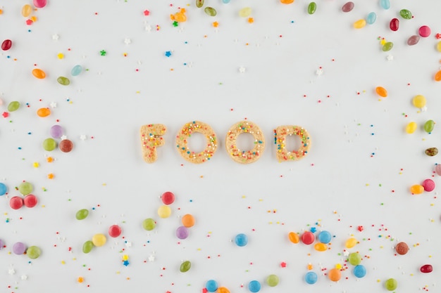 Palabras comida hecha con galletas de azúcar y chispitas de colores alrededor, concepto de postre y golosina