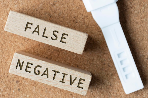 Palabras falsas negativas en un bloque de madera con un kit de prueba de embarazo