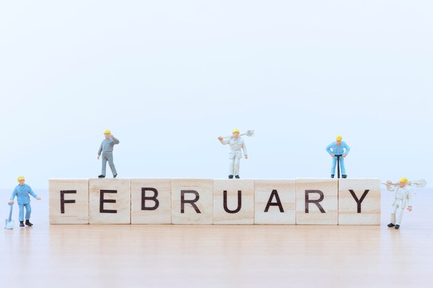 Palabras de febrero con trabajador de personas en miniatura