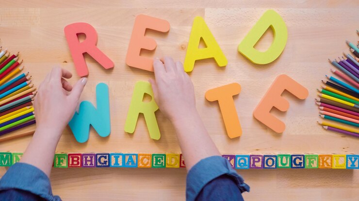 Foto palabras leer y escribir de letras de madera multicolores sobre una mesa de madera.