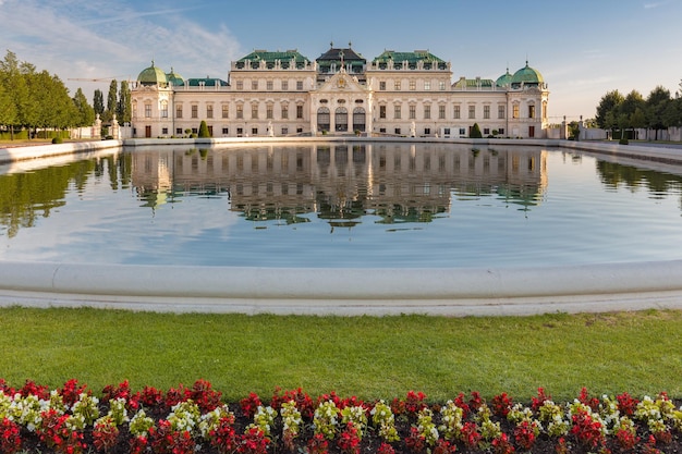Palácio barroco suntuoso Belvedere refletido na lagoa com canteiro de flores em primeiro plano, Viena, Áustria