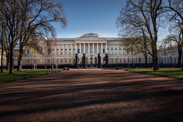 Palacio de estilo clásico detrás de la valla de castiron vista desde el jardín público San Petersburgo Rusia