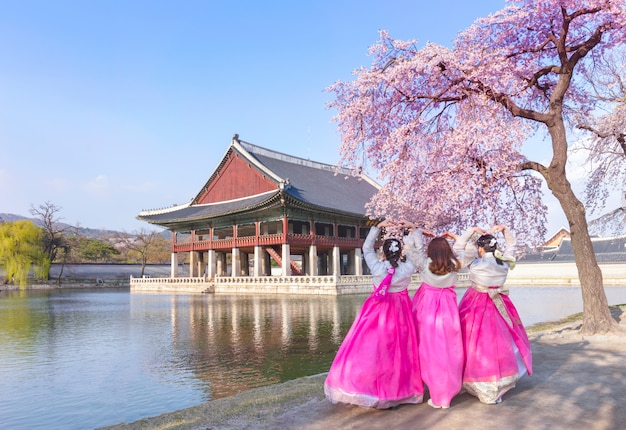 Palacio Gyeongbokgung con vestido nacional coreano y flor de cerezo en primavera