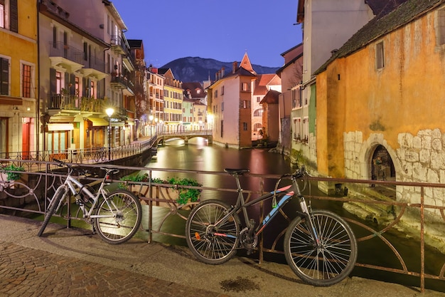 El Palais de l'Isle, puente con bicicletas y río Thiou durante la hora azul de la mañana en la ciudad vieja de Annecy, Venecia de los Alpes, Francia