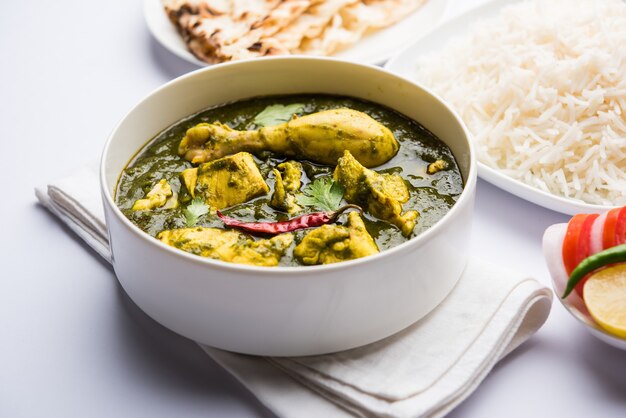 Palak o espinacas Pollo o Murg Saagwala servido en un bol con Naan y arroz