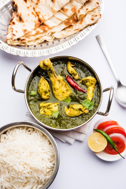 Palak o espinacas Pollo o Murg Saagwala servido en un bol con Naan y arroz