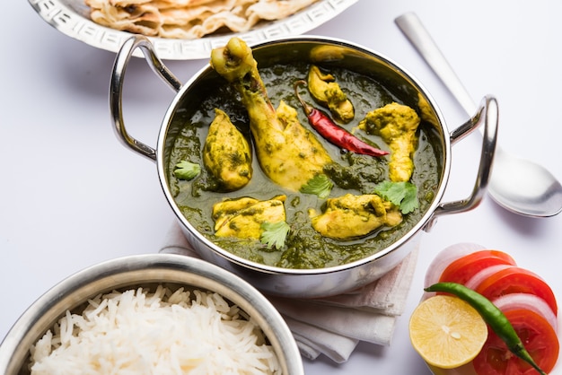 Palak o espinacas Pollo o Murg Saagwala servido en un bol con Naan y arroz