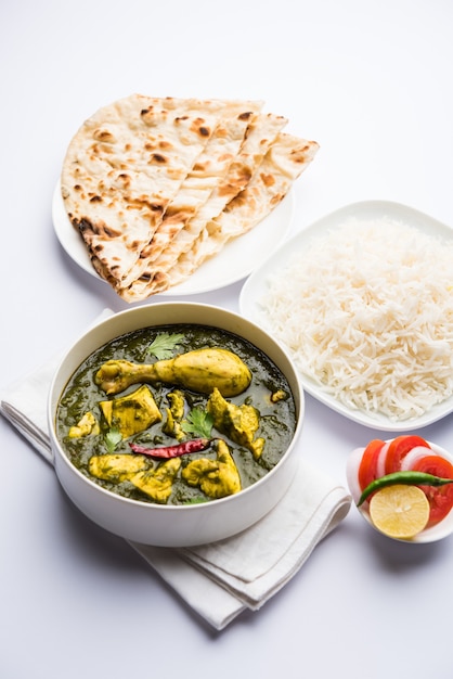 Palak oder Spinat Chicken oder Murg Saagwala serviert in einer Schüssel mit Naan und Reis