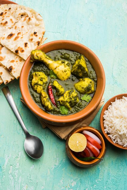 Palak oder Spinat Chicken oder Murg Saagwala serviert in einer Schüssel mit Naan und Reis