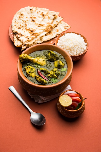 Palak oder Spinat Chicken oder Murg Saagwala serviert in einer Schüssel mit Naan und Reis