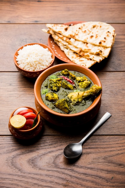 Palak oder Spinat Chicken oder Murg Saagwala serviert in einer Schüssel mit Naan und Reis