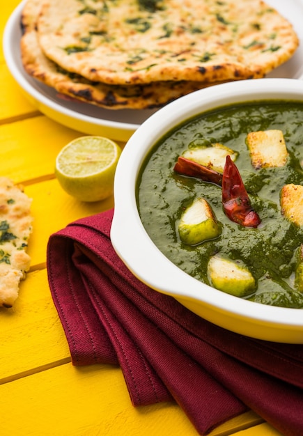 Palak Paneer Curry aus Spinat und Hüttenkäse, beliebtes indisches gesundes Mittag- oder Abendessen, serviert in einem Karahi mit Roti oder Chapati über stimmungsvollem Hintergrund. selektiver Fokus