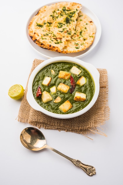 Palak Paneer Curry compuesto de espinacas y requesón, menú popular indio de comida saludable para el almuerzo o la cena, servido en un Karahi con Roti o Chapati sobre un fondo de mal humor. enfoque selectivo