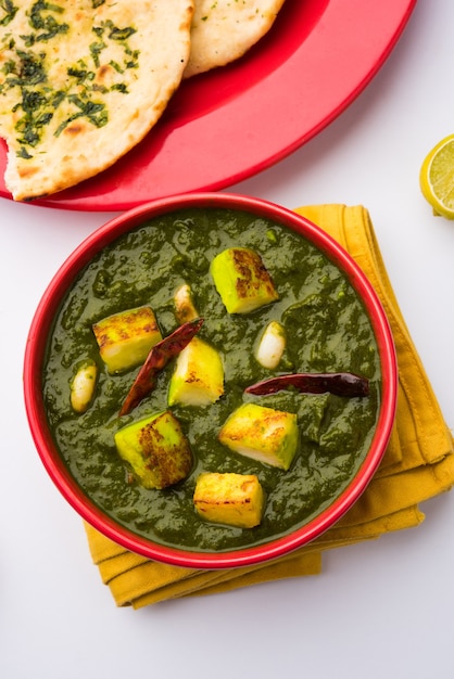 Palak Paneer Curry compuesto de espinacas y requesón, menú popular indio de comida saludable para el almuerzo o la cena, servido en un Karahi con Roti o Chapati sobre un fondo de mal humor. enfoque selectivo