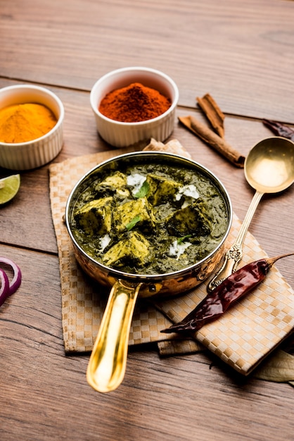 Palak Paneer Curry feito de espinafre e queijo cottage, servido em uma tigela ou panela com roti ou arroz