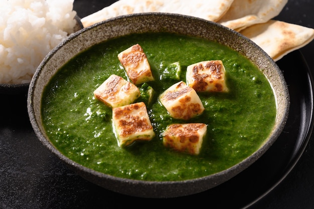 Palak paneer de espinacas y queso sobre negro
