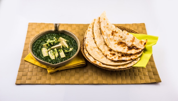 Palak paneer o curry de espinacas y requesón es una receta de plato principal saludable en la India, servida con roti o chapati o naan, enfoque selectivo