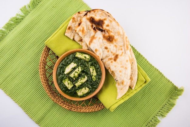 Palak paneer o curry de espinacas y requesón es una receta de plato principal saludable en la India, servida con roti o chapati o naan, enfoque selectivo