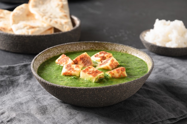 Palak Paneer serviert Basmatireis auf Grau