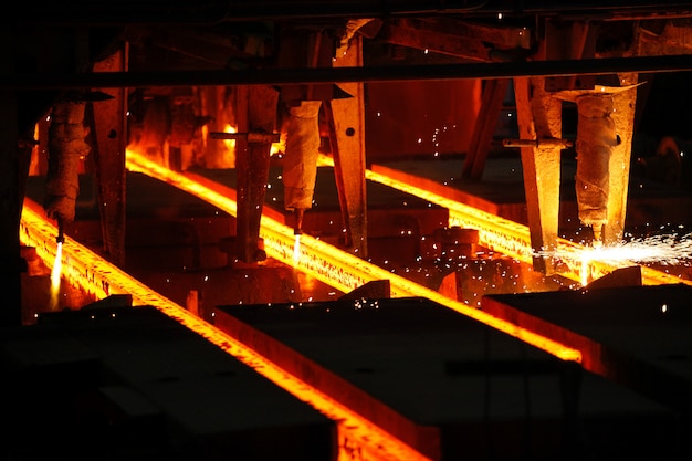 Foto palanquillas de acero en corte con soplete en planta metalúrgica. producción metalúrgica, industria pesada, ingeniería, siderurgia.