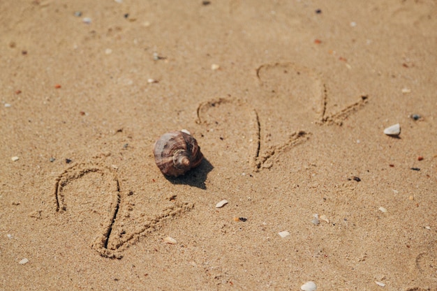 Palavra 2022 escrita na areia de uma praia. Texto de Ano Novo 2022 na praia do mar. Férias relax