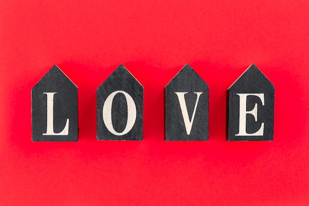 Palavra amor de letras de madeira em um plano de fundo vermelho