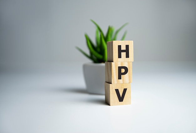 Palavra de HPV escrita com bloco de madeira ao lado da planta