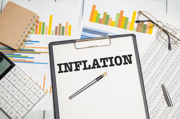 Palavra de inflação no bloco de notas e calculadora e gráficos