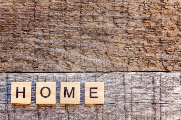 Palavra de letras para casa de inscrição em fundo de madeira