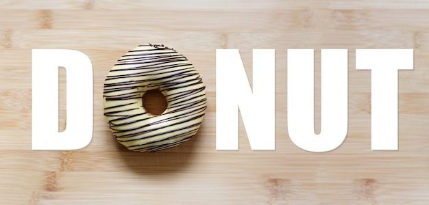 Palavra donut, com donut em vez da letra 'o', na mesa de madeira.
