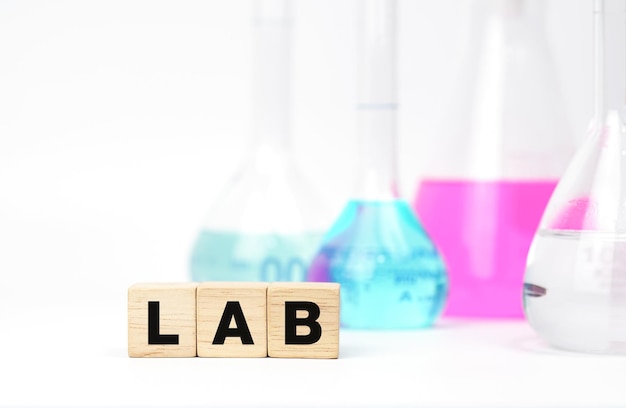 Palavra LAB em cubos de madeira e vidraria química Módulos de madeira com texto LABS Tijolos de madeira entre