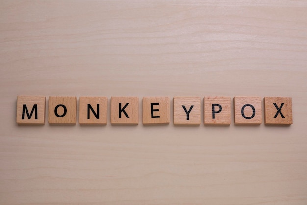 Palavra Monkeypox feita de quadrados na vista superior da mesa de madeira