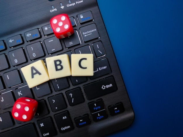 Palavra preta dos dados e dos brinquedos do teclado vermelho com a palavra ABC no fundo azul