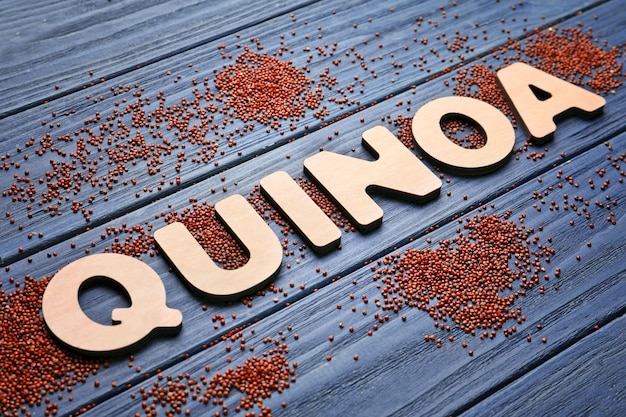 Palavra QUINOA feita de letras de madeira e sementes na mesa