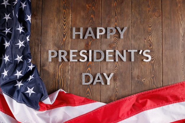 Palavras feliz dia dos presidentes colocados com letras reais na placa de madeira perto da bandeira dos EUA