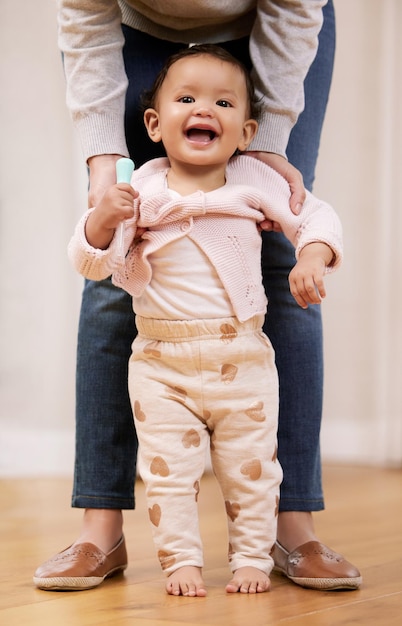 Palavras não podem expressar a alegria de uma nova vida. Foto de uma mãe ajudando seu bebê aprendendo a andar em casa.