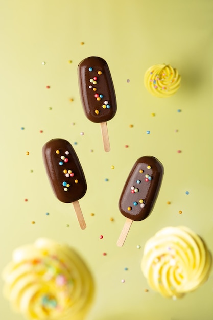 Paleta de chocolate de levitación de concepto de vacaciones con decoraciones sobre un fondo amarillo