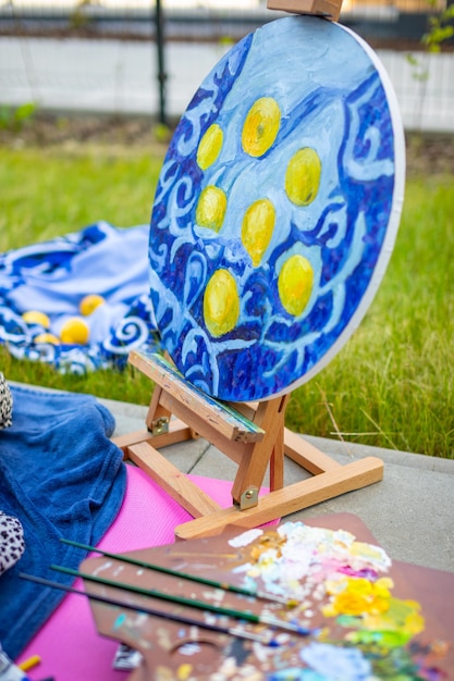 Paleta com tintas e pincéis multicoloridos mulher pintando quadro