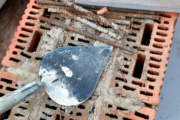 Paleta de construcción para colocar ladrillos y bloques Herramienta de construcción de un albañil Herramienta de trabajo manual en el fondo de albañilería