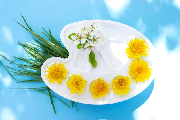 Paleta de aquarela com flores flores de dente-de-leão amarelas em um fundo azul Conceito de arte de verão em um fundo brilhante