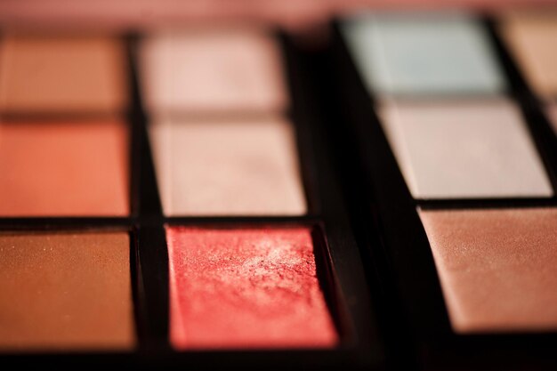 Paleta de maquiagem colorida com sombras e close up blush. Foco seletivo.